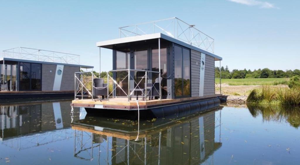 a house on a dock on a body of water at Couston Lakes Resorts in Bathgate