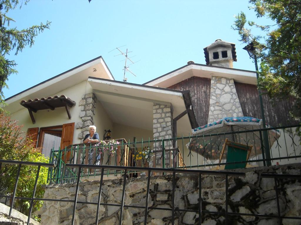 a man standing on a balcony of a house at Esclusivo chalet immerso nel verde in Filettino Graziani