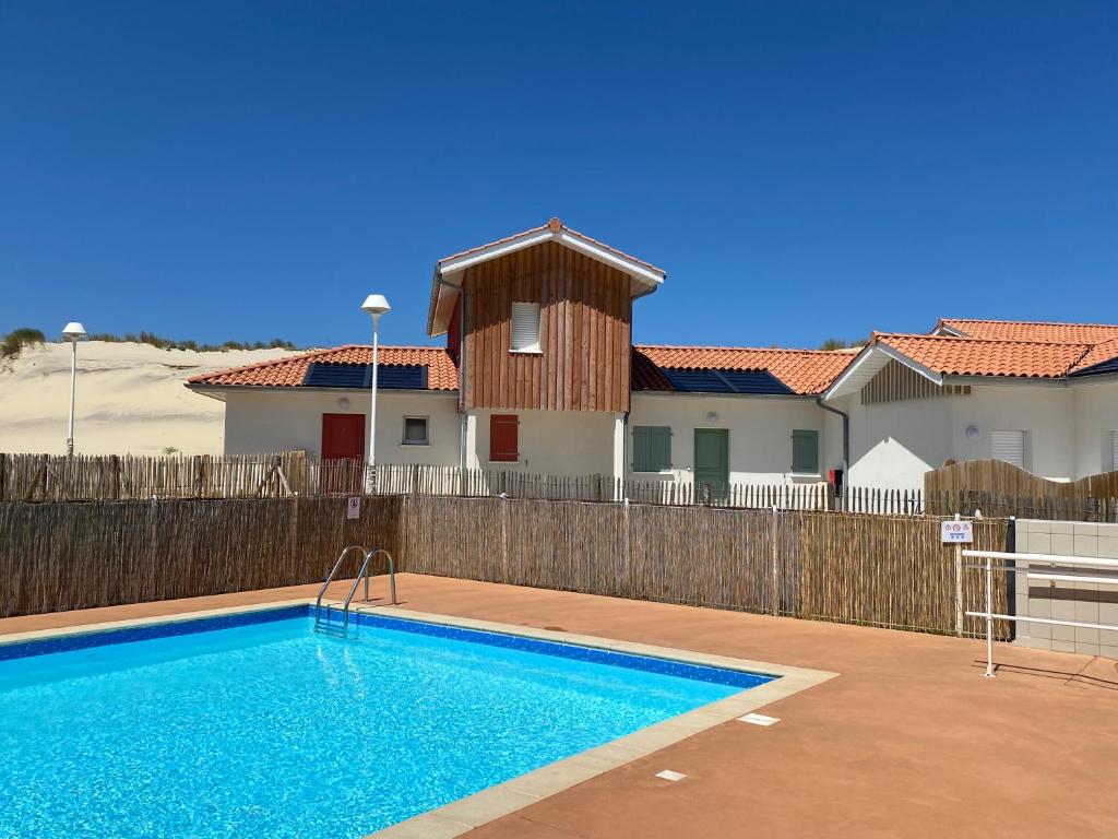 a swimming pool in front of a house at Residence Plage Oceane in Biscarrosse-Plage