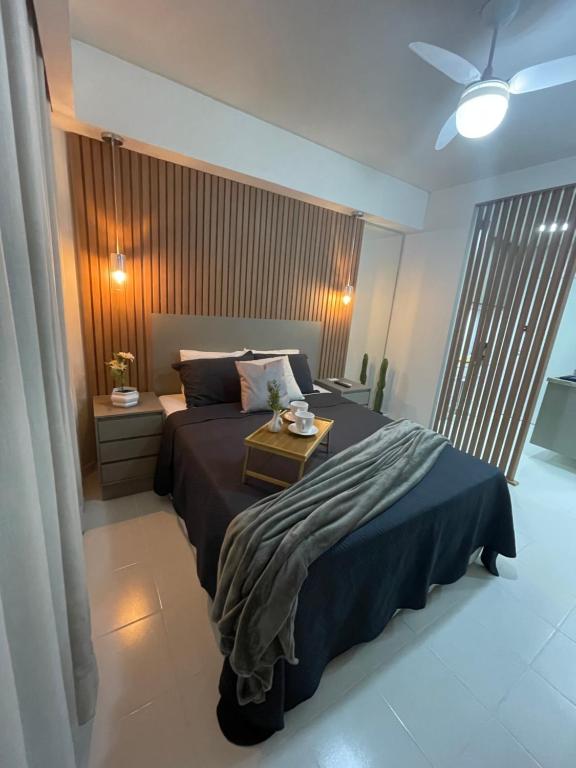 a bedroom with a bed with a table on it at Loft encantador e refinado in Ribeirão Preto