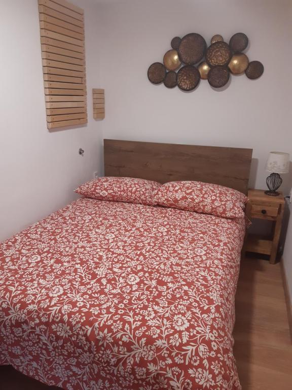 een slaapkamer met een bed met een rood dekbed bij Apartma LUPIS in Podvolovljek