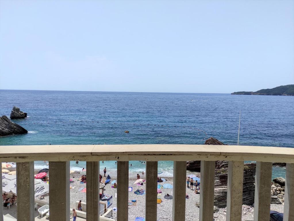 une vue d'une plage avec des gens dans l'eau dans l'établissement Apartments Altea, à Rafailovici