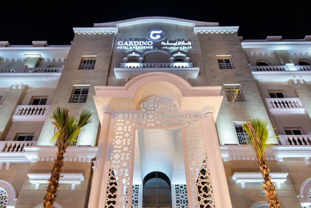 a building with palm trees in front of it at Gardino Hotel & Residence in Riyadh