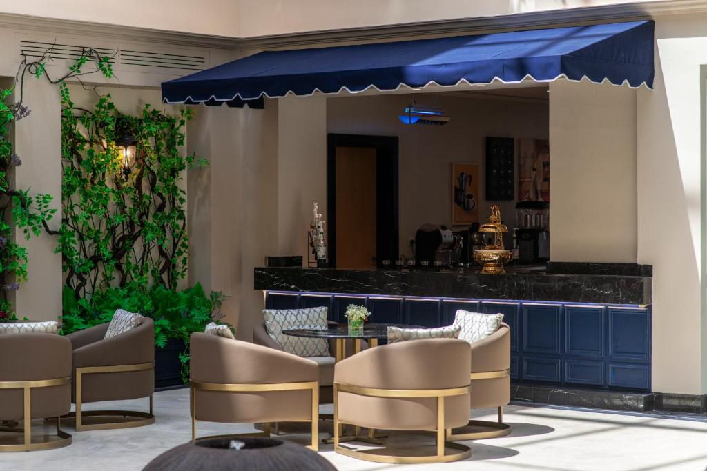 a patio with chairs and a table and a bar at Gardino Hotel & Residence in Riyadh