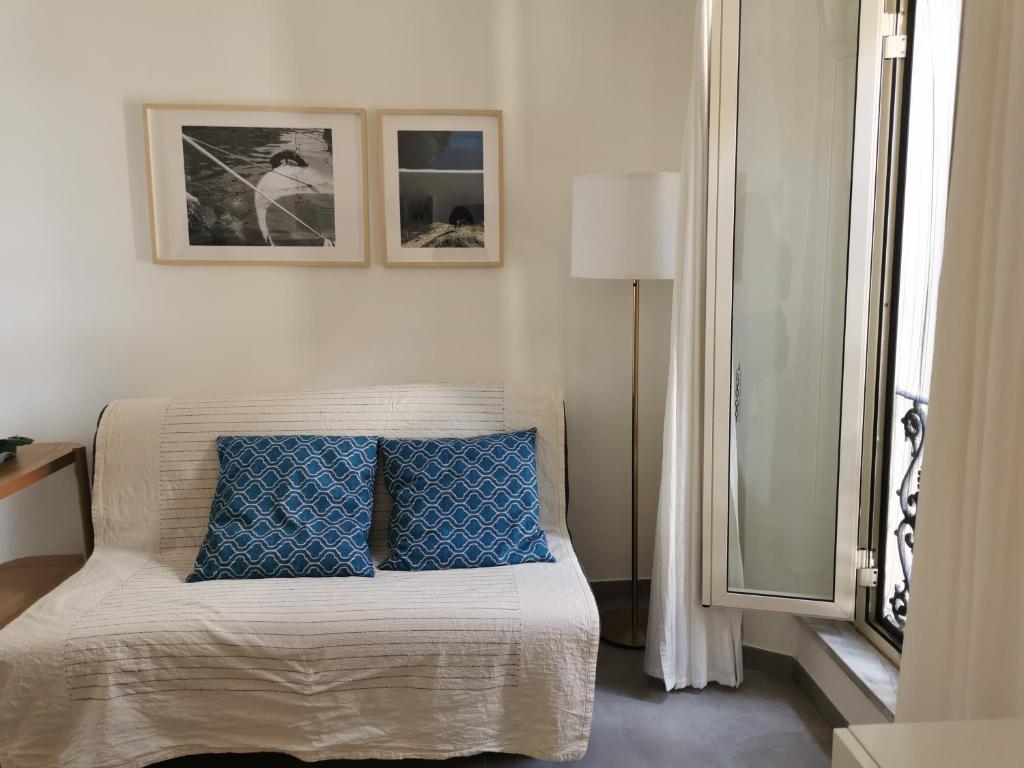 a bedroom with a bed with blue pillows on it at Domus Taura in Terracina