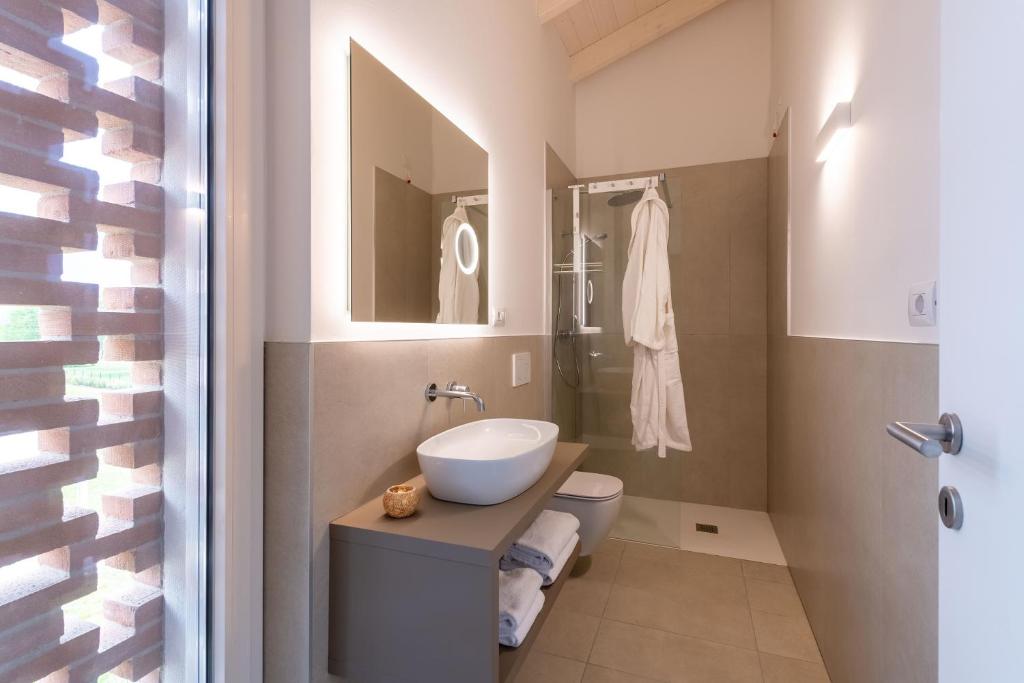 a bathroom with a sink and a toilet at Pareus Beach Resort in Caorle