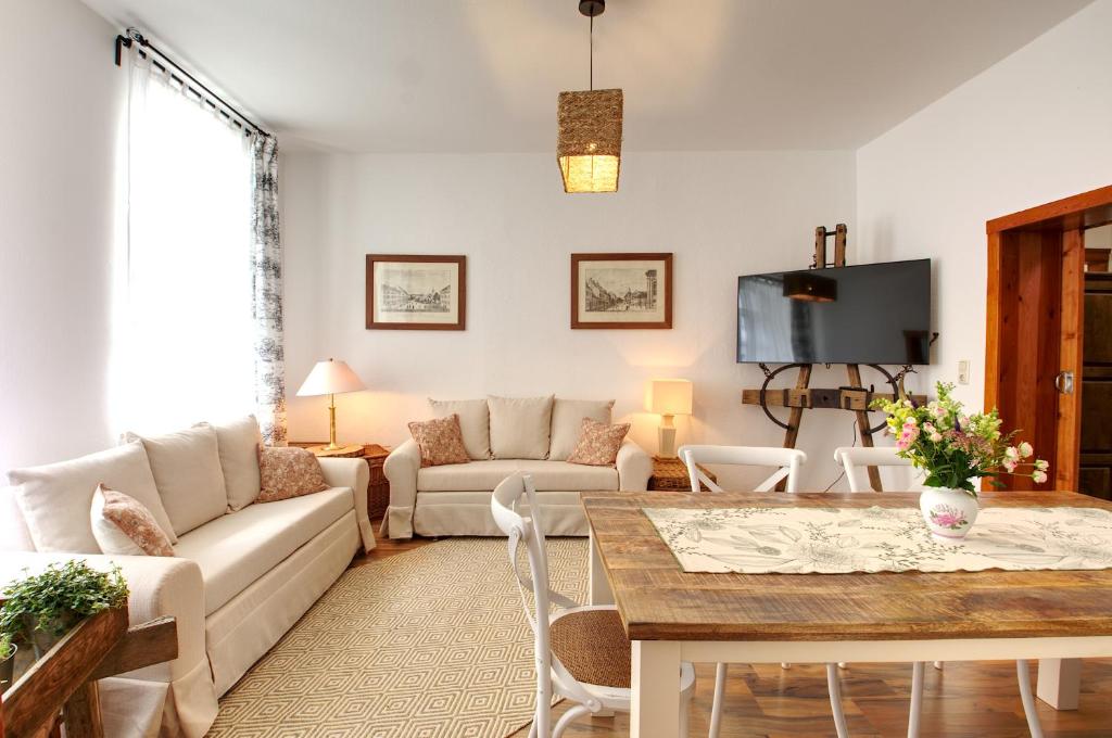 ein Wohnzimmer mit einem Sofa und einem Tisch in der Unterkunft Ferienwohnung LANDHAUSSUITE Annaberg-Buchholz in Annaberg-Buchholz