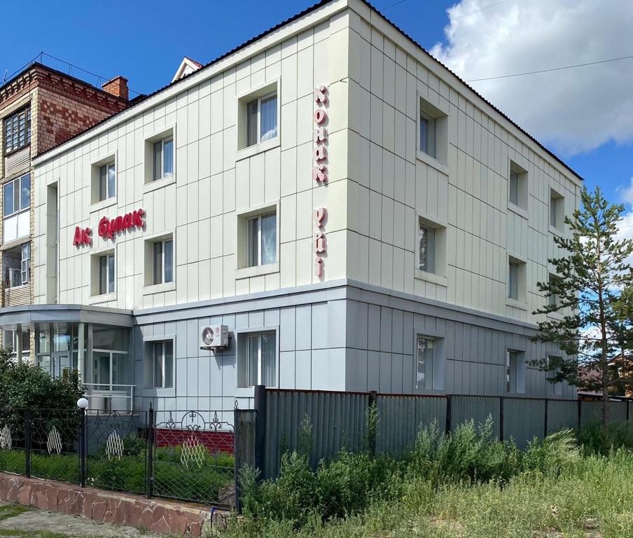 un edificio blanco con una valla delante en Отель Ак Булак en Borovoye