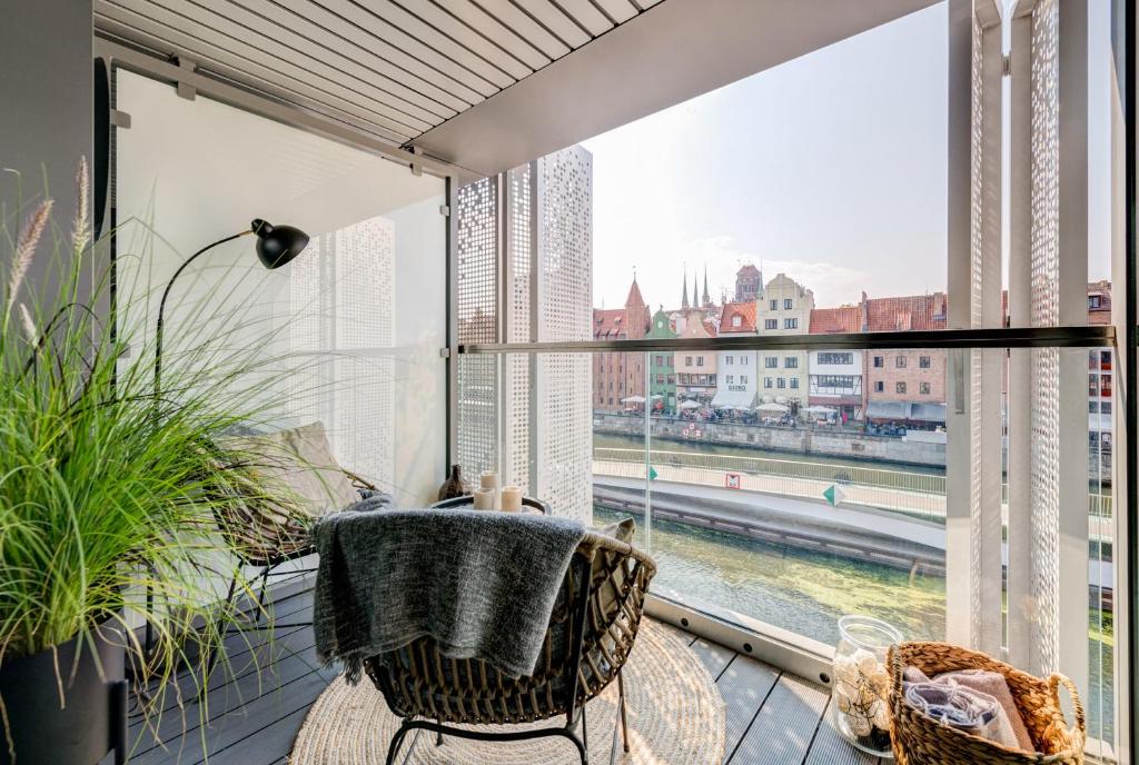 a balcony with a table and chairs and a large window at The Black Crane Apartment in Gdańsk
