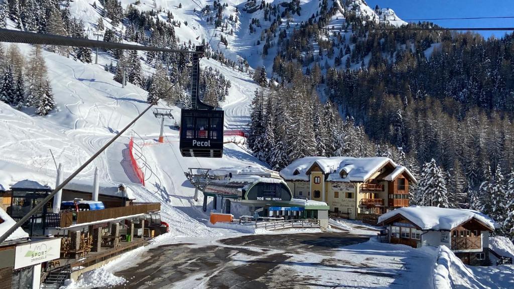 una estación de esquí en la nieve con un remonte en Hotel Tita Piaz, en Canazei