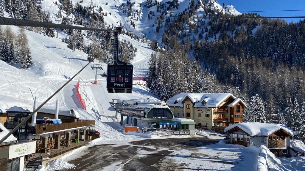 a ski resort in the snow with a ski lift at Hotel Tita Piaz in Canazei