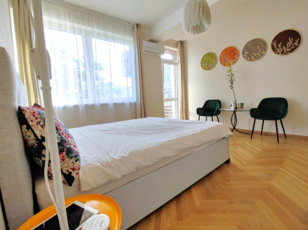 una camera con un letto e due sedie e una finestra di 4 bedroom apartment in city center with air conditioning a Bratislava