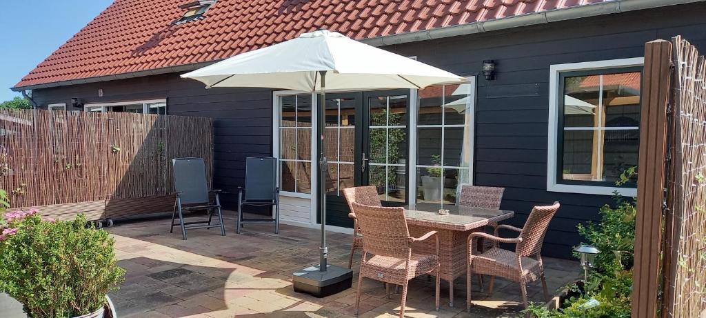 斯哈倫代克的住宿－Beachloft Zeeland nr.2，庭院配有桌椅和遮阳伞。