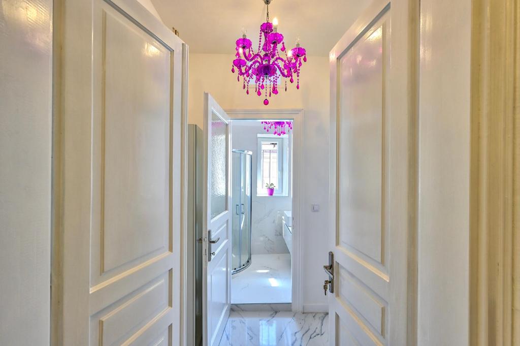 a bathroom with a chandelier and a white tub at Collins Amethyst Center in Pula