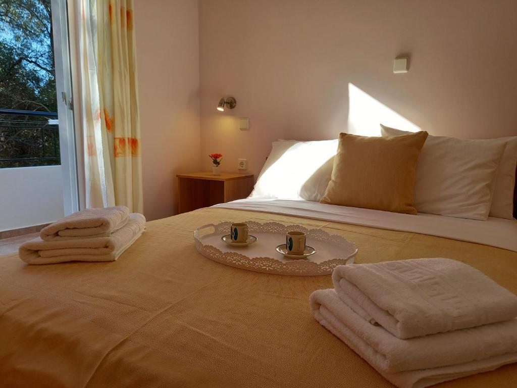 a bedroom with a bed with towels on it at Olivo Nydri in Nydri