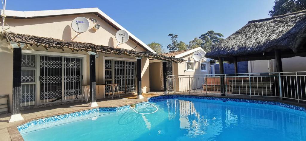 a swimming pool in front of a house at Lytton Cresent B&B in Pinetown