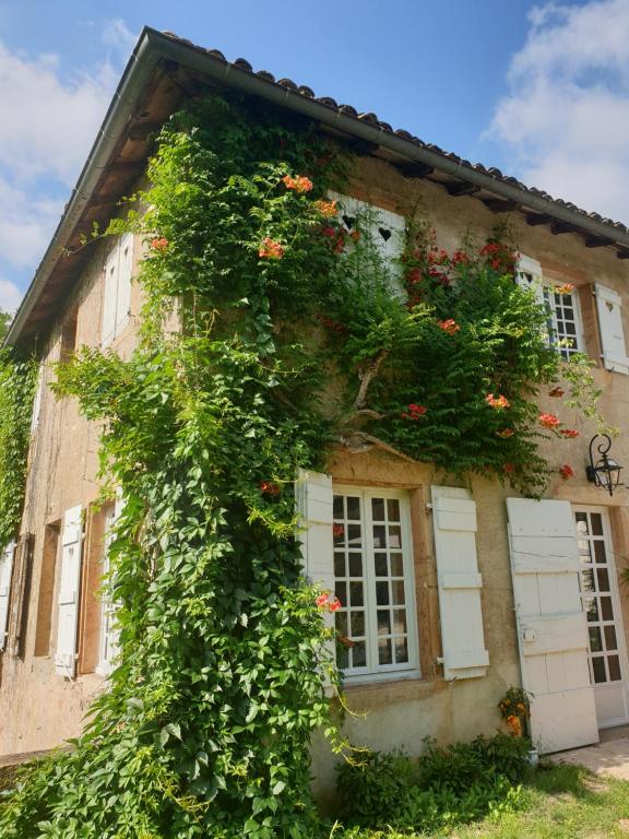 a building with flowers on the side of it at LE CARGE D’ARLAY in Charnay-lès-Mâcon