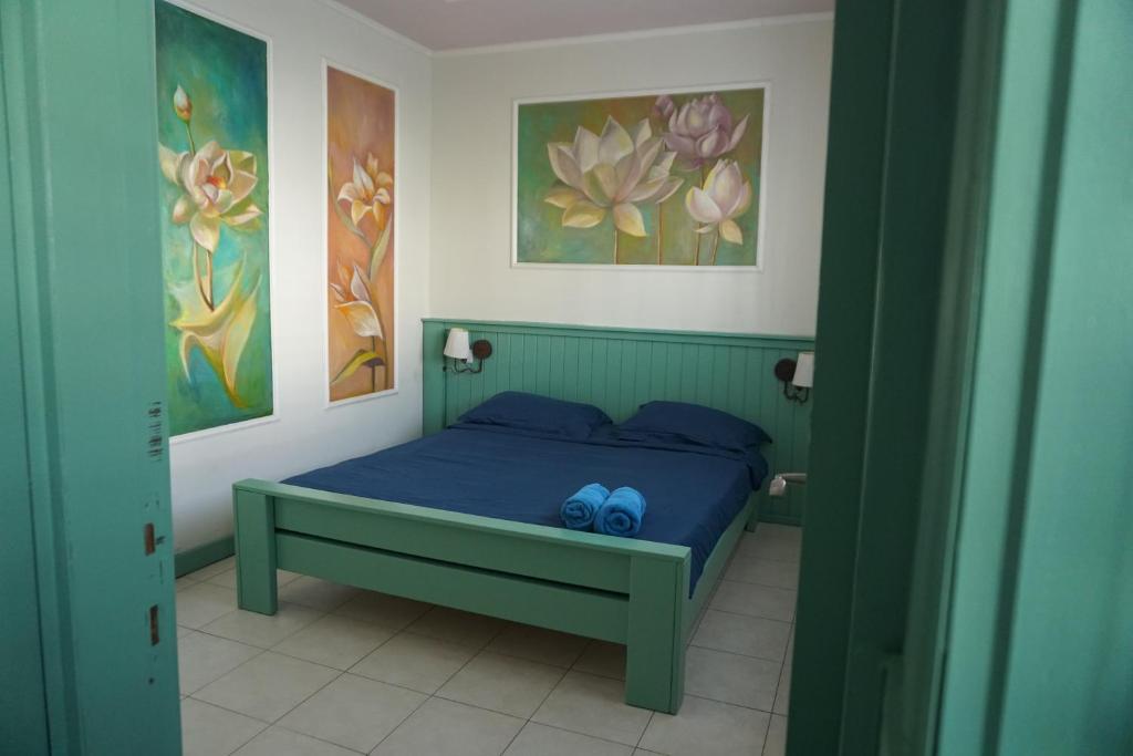 een slaapkamer met een groen bed met twee blauwe schoenen erop bij Passion Fruit Apartment in Ashkelon