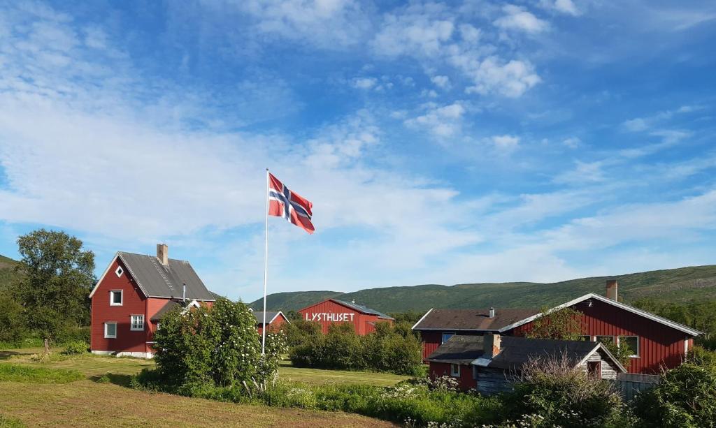 una bandiera britannica battente di fronte a una casa rossa di VARANGER KITE CAMP a Austertana