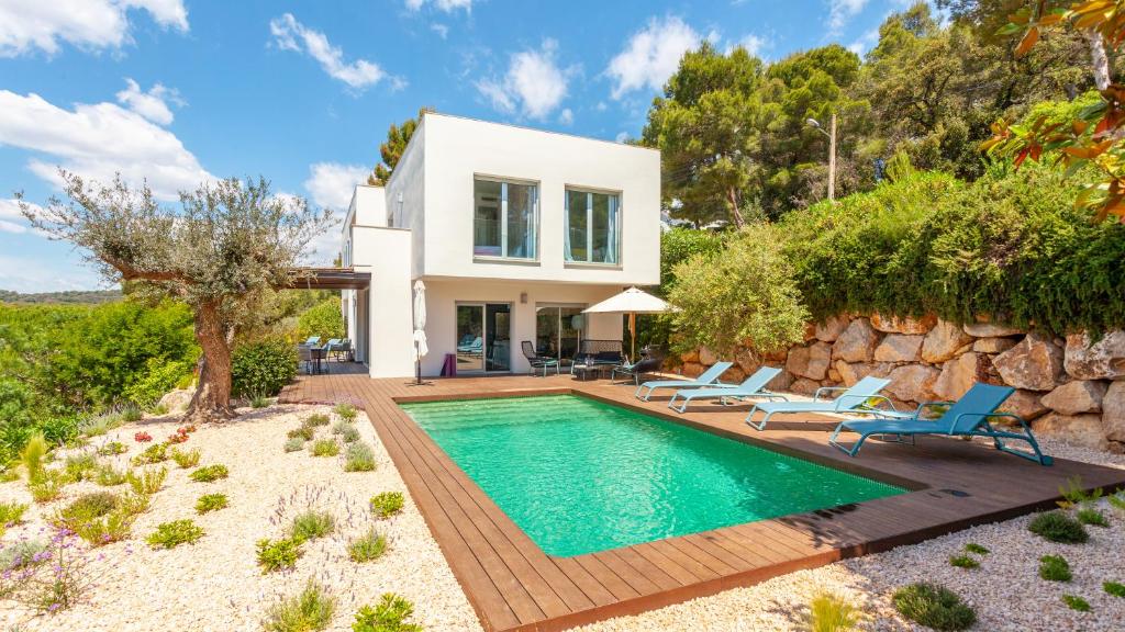een villa met een zwembad en een huis bij Exmora in Tamariu