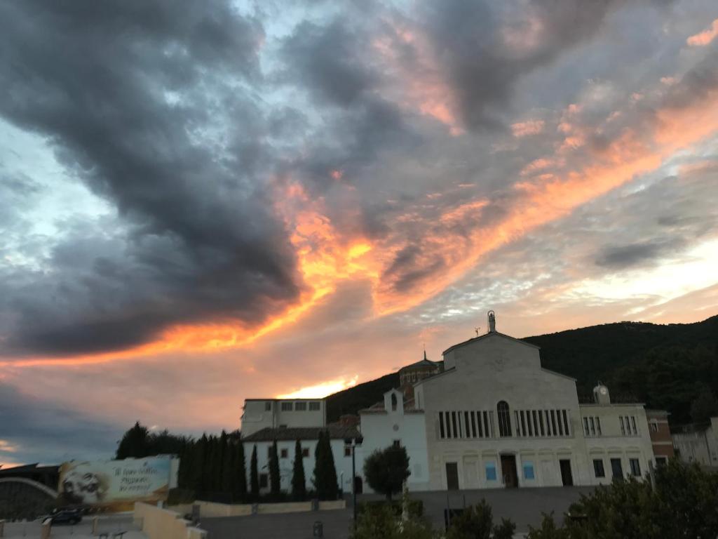 a white building with a sunset in the background at Albergo pensione Bianco in San Giovanni Rotondo