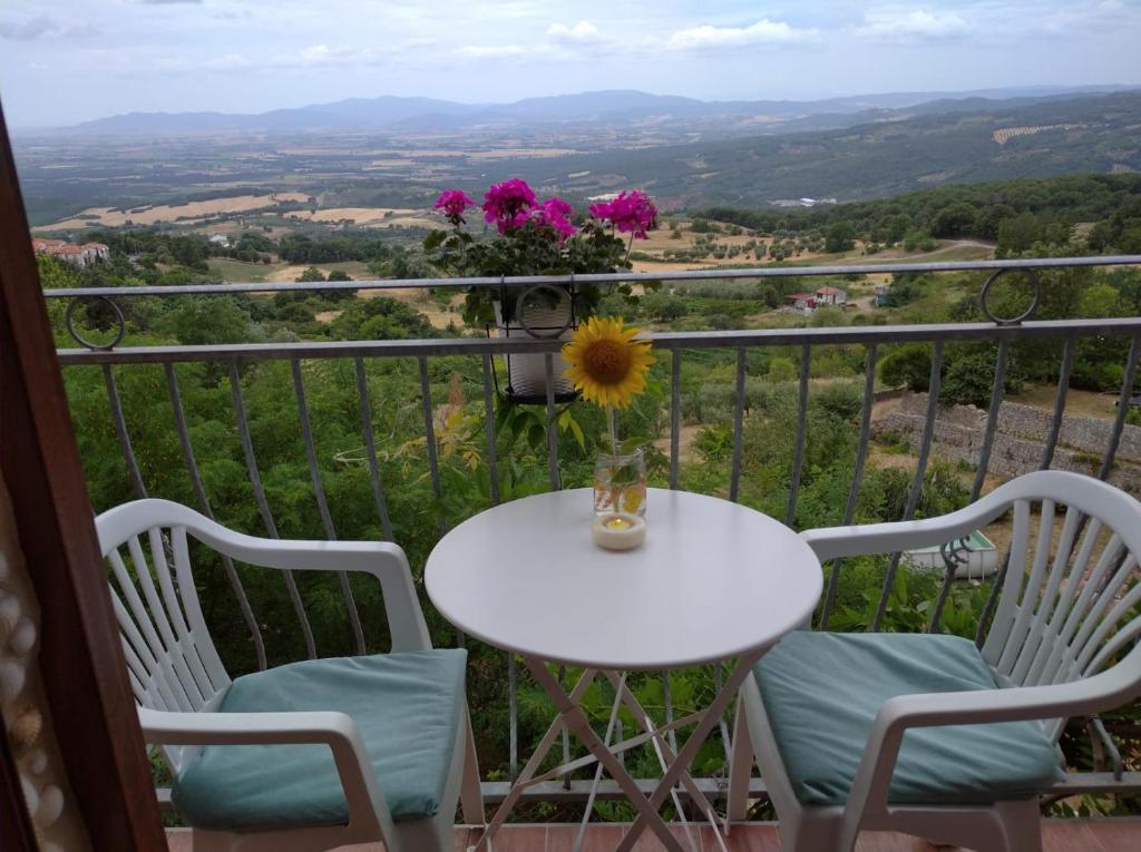 a table and chairs on a balcony with a view at Monolocale romantico in Roccastrada