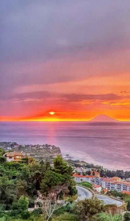 a sunset over the ocean and a city at La Piazza BeB in Tropea