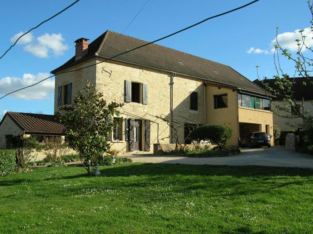 Gîte "L'helpe" dans grande maison quercynoise entre Sarlat Rocamadour في غوردون أون كيرسي: منزل من الطوب كبير مع سيارة متوقفة أمامه