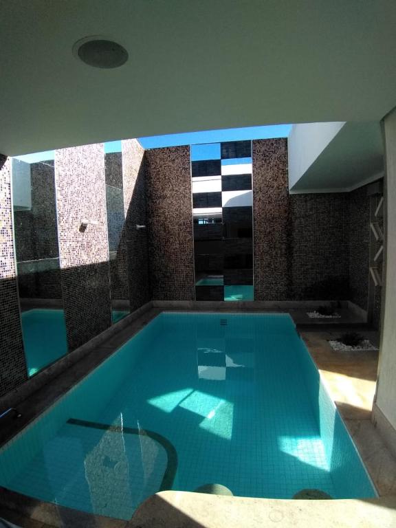 a swimming pool in a house with a blue water at Motel Colorado (Adult Only) in Brasília