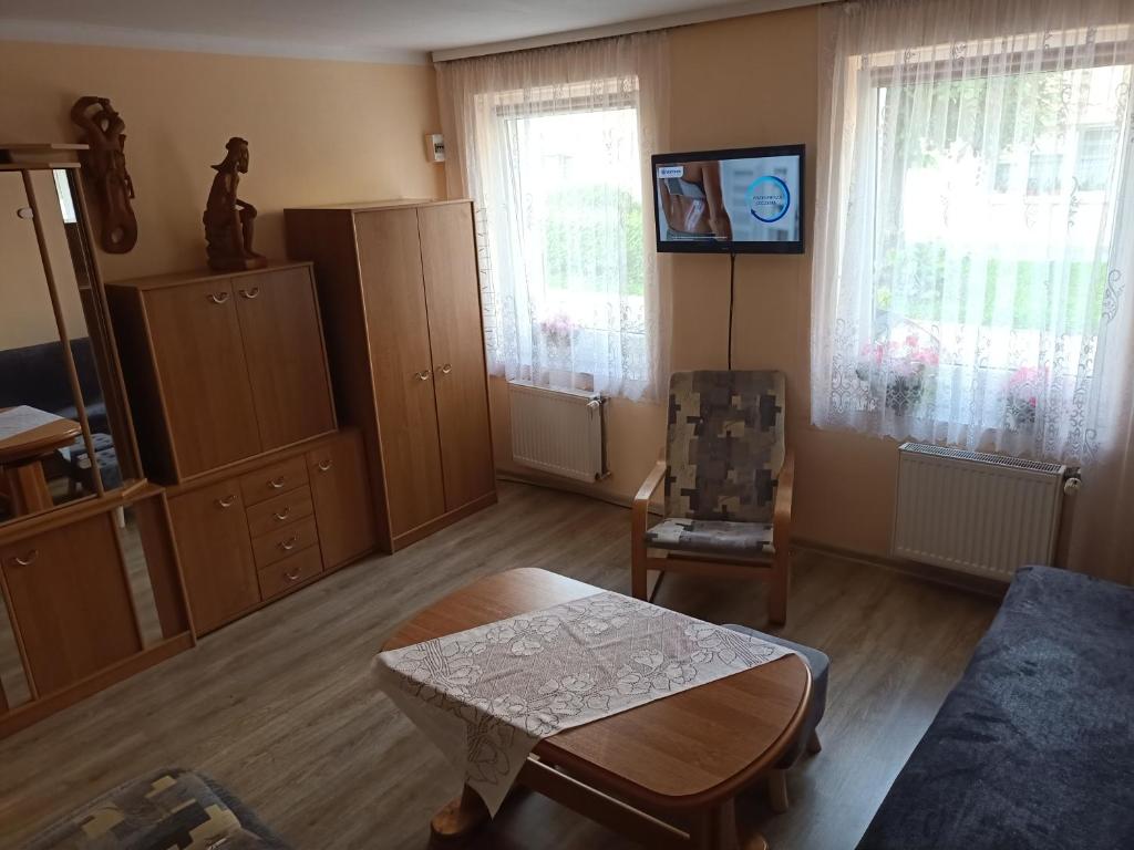 een woonkamer met een bank en een stoel bij Mieszkanie w domu wielorodzinnym in Ryn