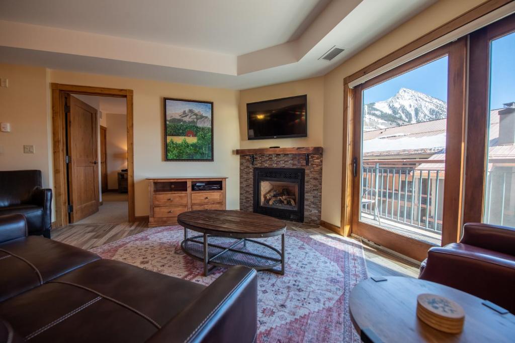 a living room with a couch and a fireplace at Beautifully Renovated Two Bedroom Condo with a Balcony in Mountaineer Square condo in Crested Butte