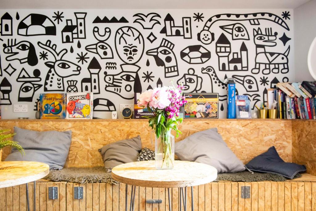 a room with a couch and a table with flowers at Haystack Hostel in Edinburgh