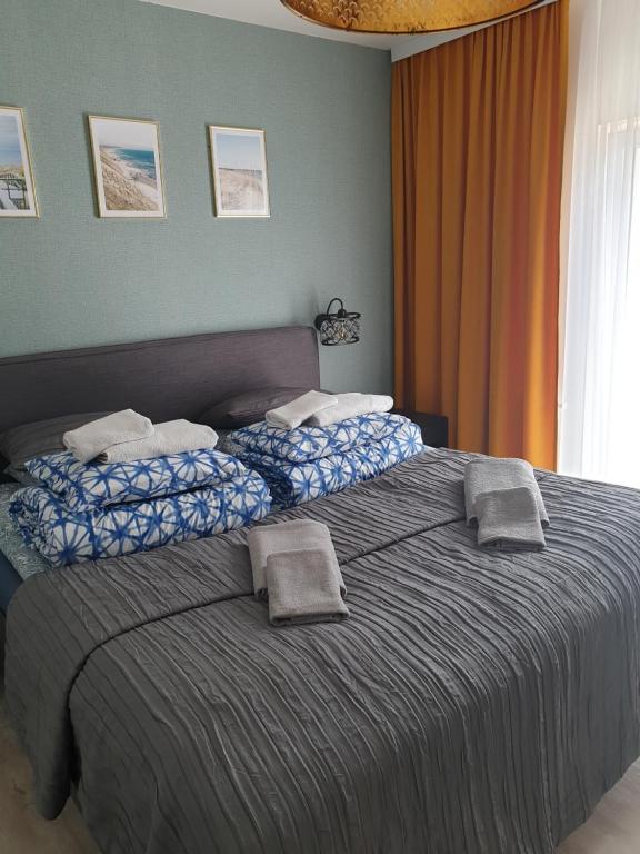 a bedroom with a large bed with towels on it at Apartament Wygodny 5 Mórz in Sianozety