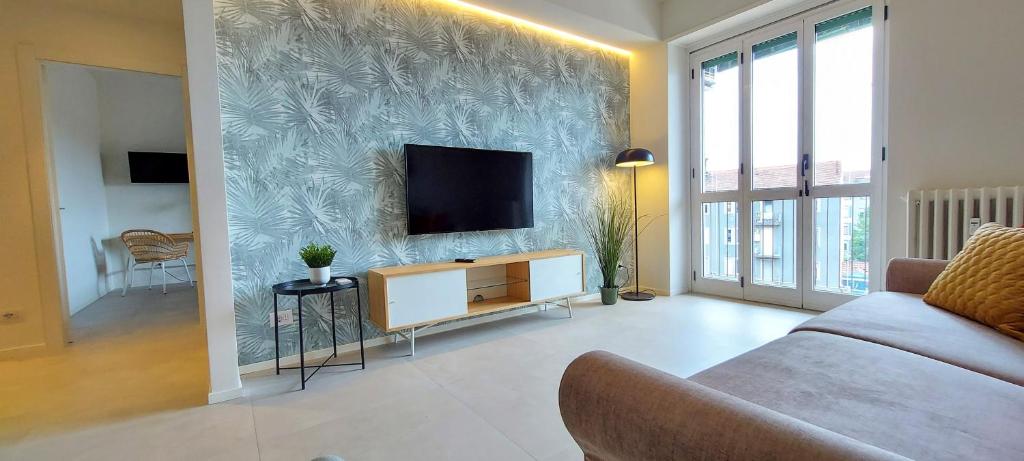 uma sala de estar com uma televisão de ecrã plano na parede em Suite Rent Milan 3 em Milão