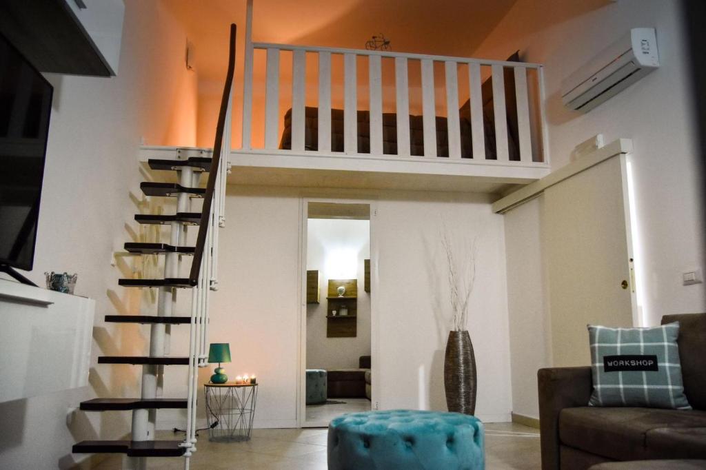 salon ze schodami i kanapą w obiekcie Casa dell arco Apartment w mieście Bari