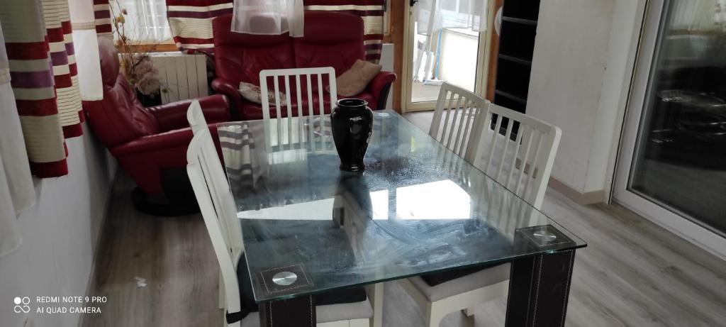 uma mesa de vidro numa sala de estar com duas cadeiras em GRAND APPARTEMENT AVEC TERRASSE & JARDIN A 5 minutes de PARIS em Cachan