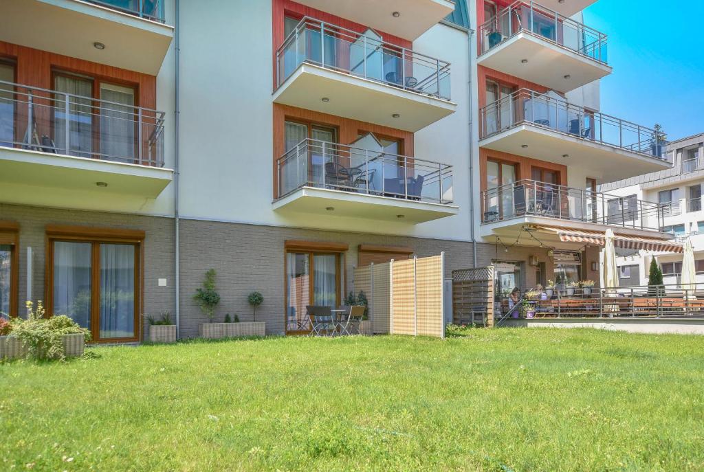 an apartment building with a lawn in front of it at Apartamenty na Wyspie - Villa Pegaz - Parking in Świnoujście