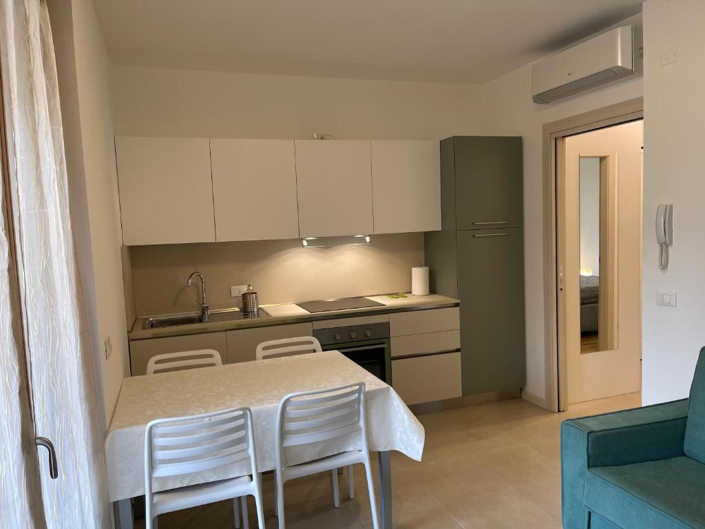 a kitchen with a table and some white cabinets at Appartamento Corallo in Sirmione