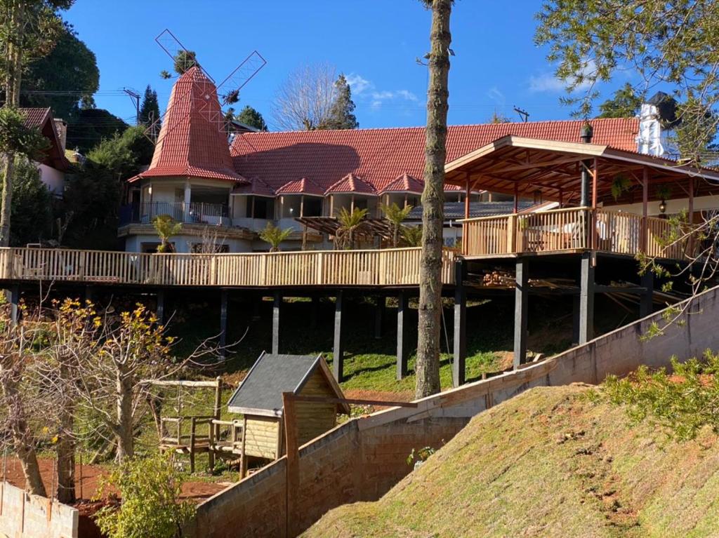 a large house with a red roof at Recanto dos Moinhos - Boutique Hotel in Campos do Jordão