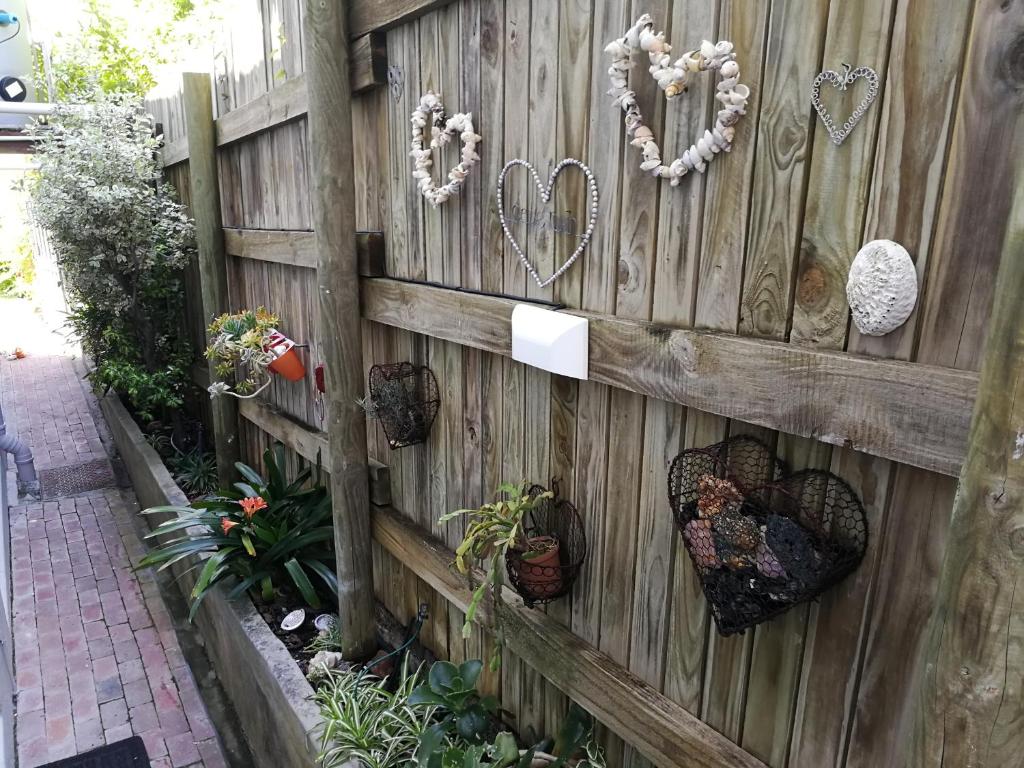 a wooden fence with hearts and plants on it at Studio Bay View in Cape Town