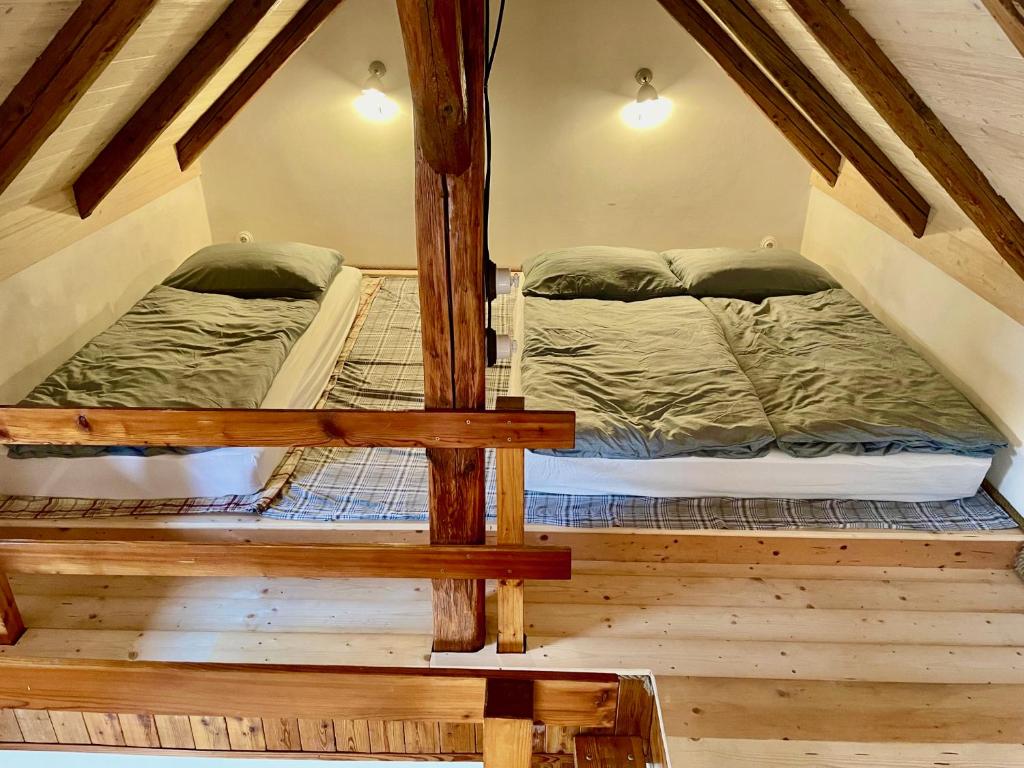 2 łóżka piętrowe w pokoju na poddaszu w obiekcie Apartmány pod Kozákem w mieście Velké Popovice