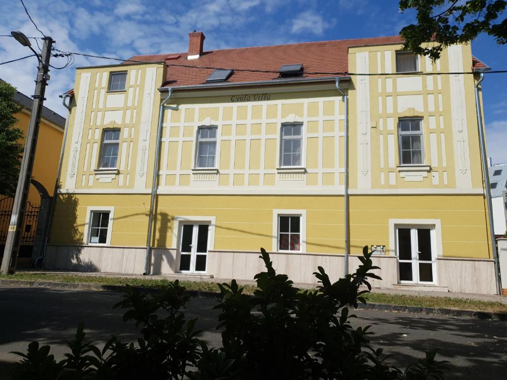 un bâtiment jaune avec un toit rouge dans l'établissement Gyula Villa, à Hévíz