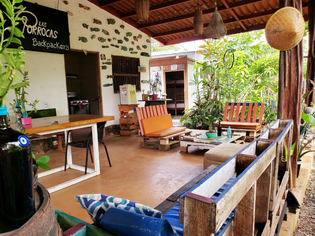 a living room with a table and chairs in a room at Las Porrocas Backpacer's in Pedasí Town