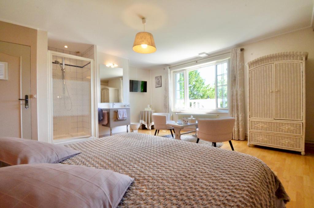 a bedroom with a bed and a table with chairs at Au bon maréchal in Giverny