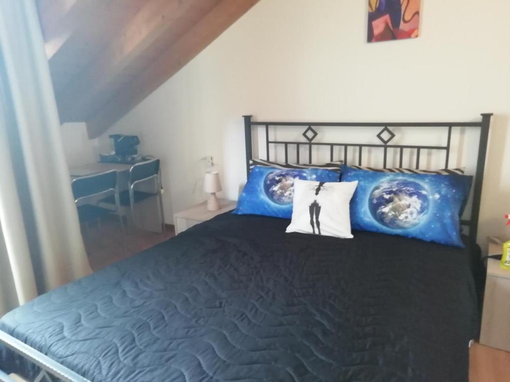 L'Angelo في أومغنا: غرفة نوم مع سرير أسود مع وسائد زرقاء