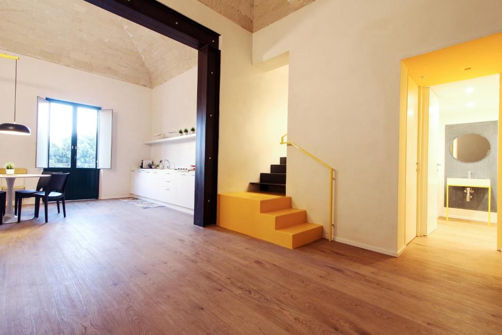 een open woonkamer met een tafel en een trap bij GialloCorallo - Casa Vacanze Trapani in Trapani