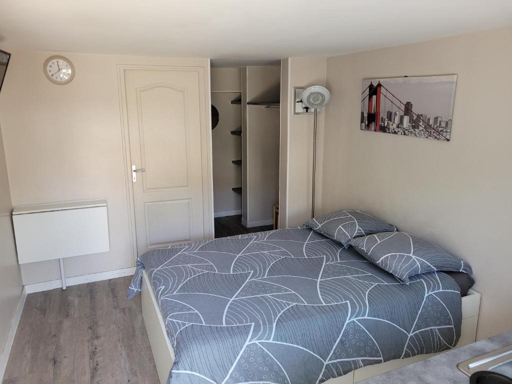 a bedroom with a bed and a clock on the wall at Studio Buffon in Mitry-Mory