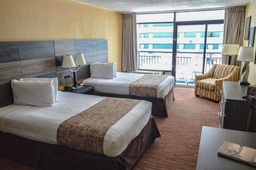 um quarto de hotel com duas camas e uma varanda em Landmark 704 em Myrtle Beach