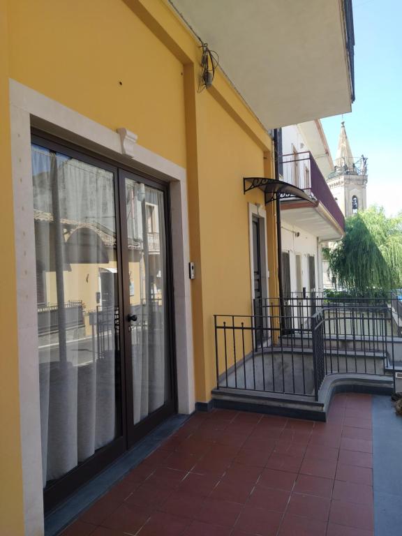 - un bâtiment jaune avec une porte et un balcon dans l'établissement Gelsonero Apartments, à Ragalna
