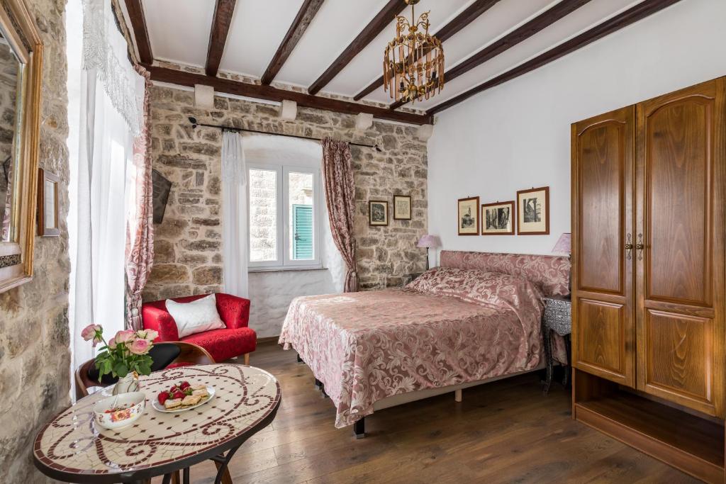um quarto com uma cama e uma mesa em Apartments Kaleta em Split